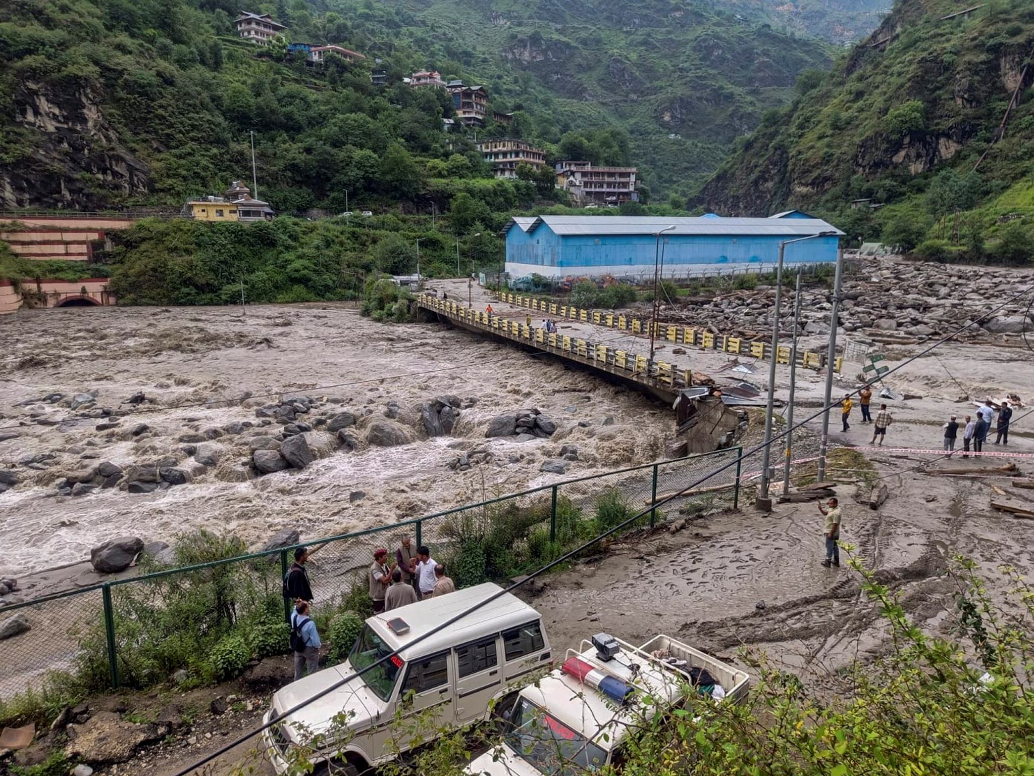 People stand near a damaged area at Sainj valley amid flash floods following cloudbursts in Kullu district (Photo: PTI)