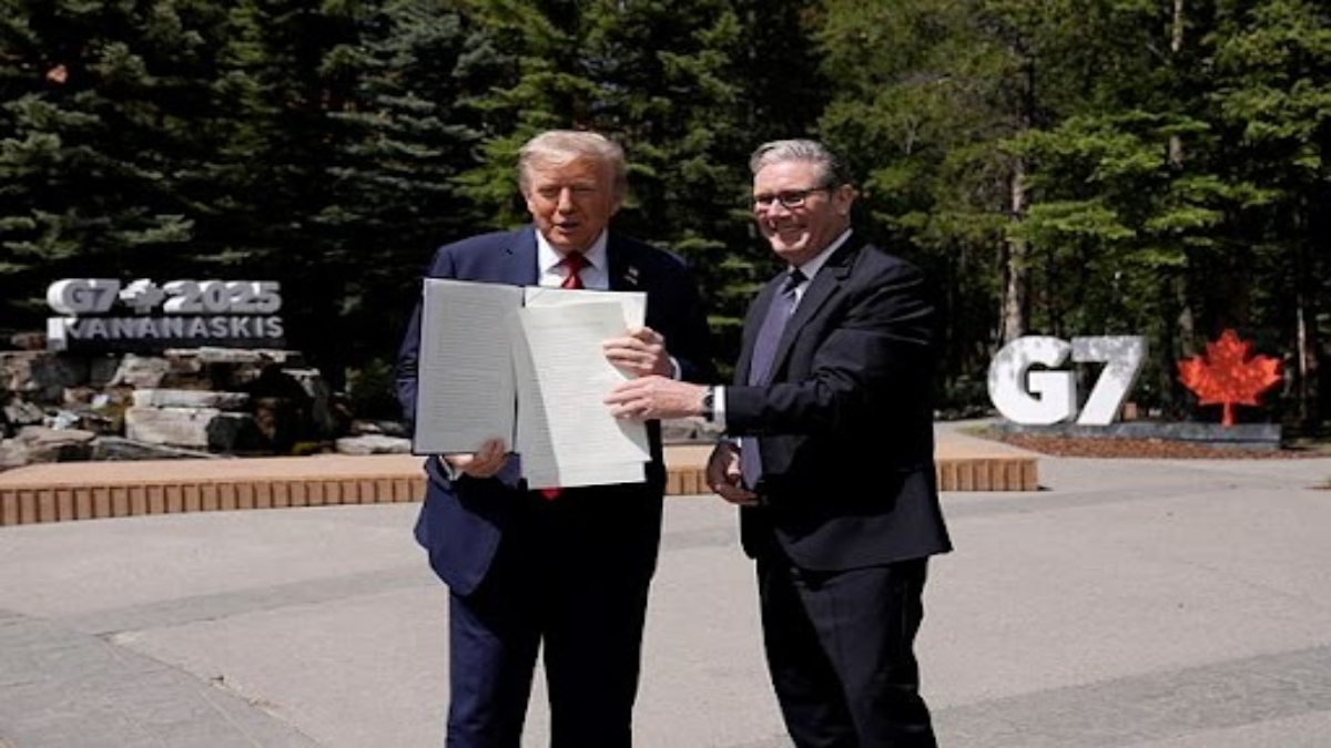 U.S. President Donald Trump, left, holds a U.K.-U.S. trade agreement with Britain's Prime Minister Keir Starmer while speaking to the media at the G7 summit in Kananaskis, Alberta, Monday, June 16, 2025. (Stefan Rousseau/Pool Photo via AP)