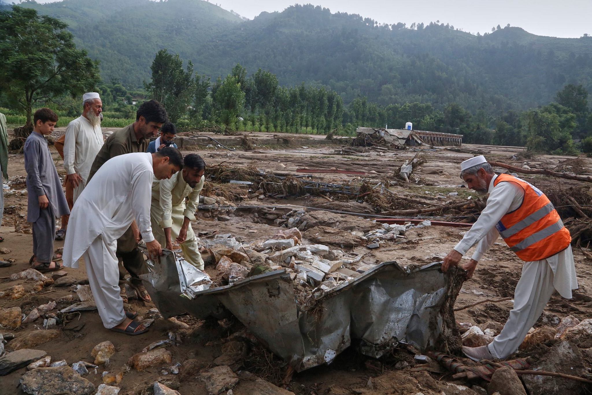 Local residents search through an area covered with mud and debris (AP Photo)