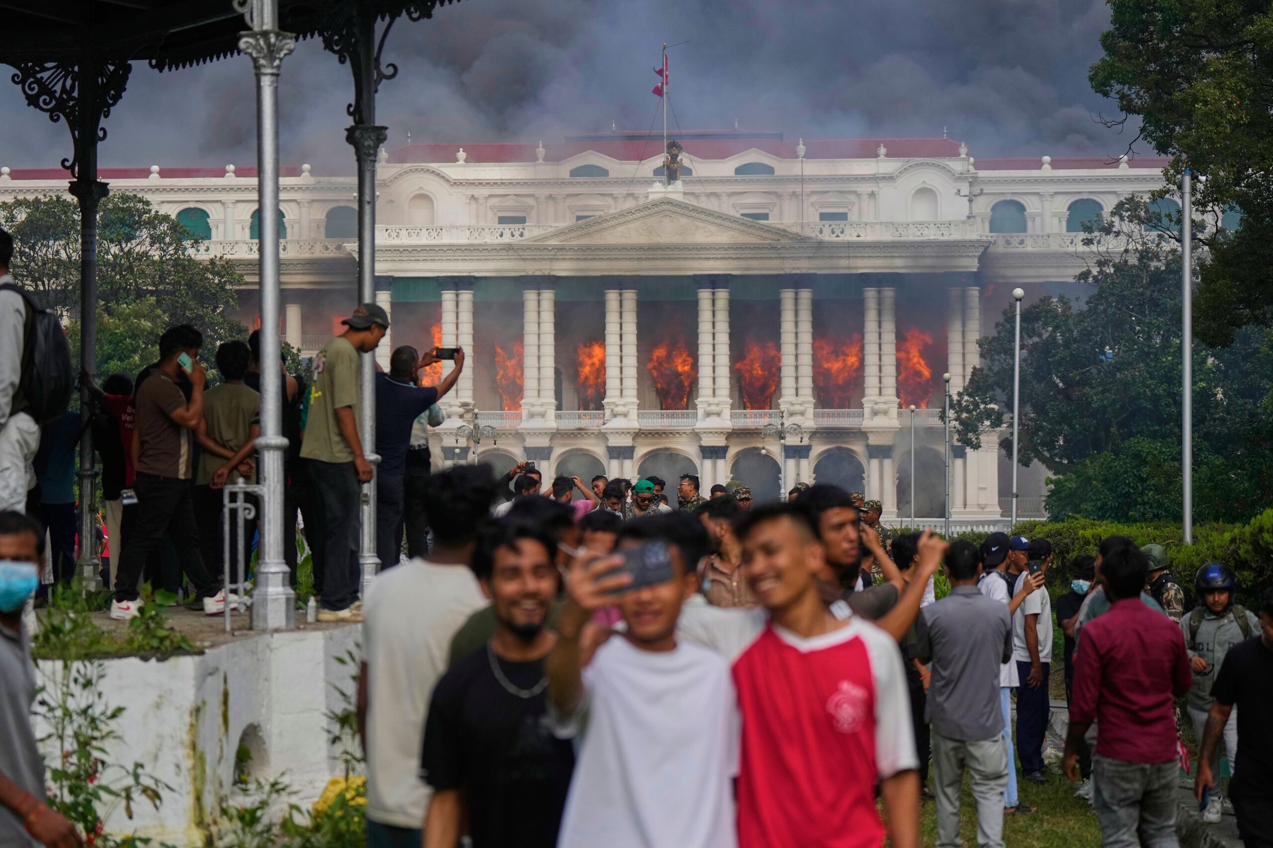 Protesters take selfies and celebrate at the Singha Durbar, the seat of Nepal's government's various ministries and offices (AP Photo)
